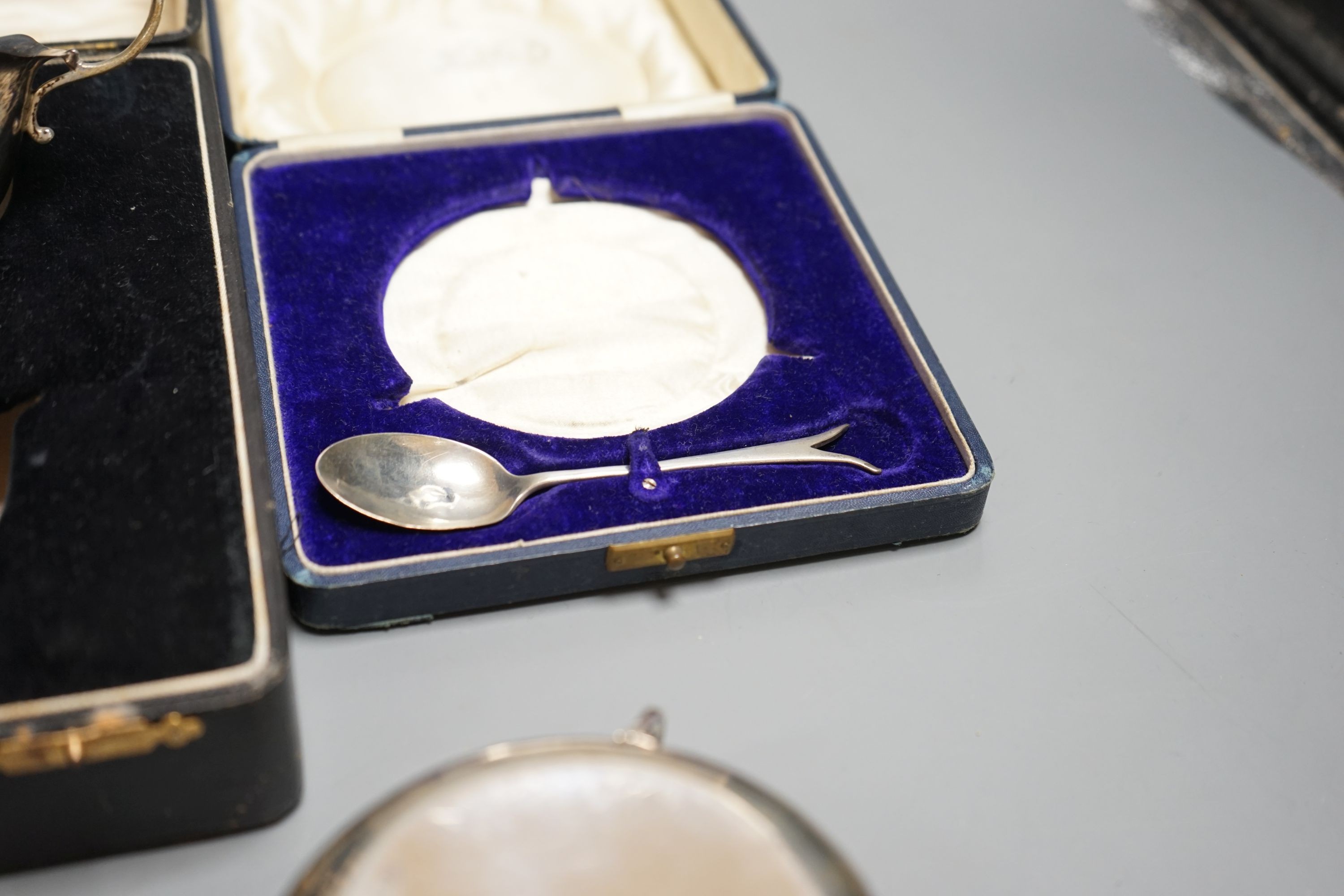 A cased George V silver three handle bowl and spoon, Birmingham, 1928 and a silver sauceboat, 7oz.